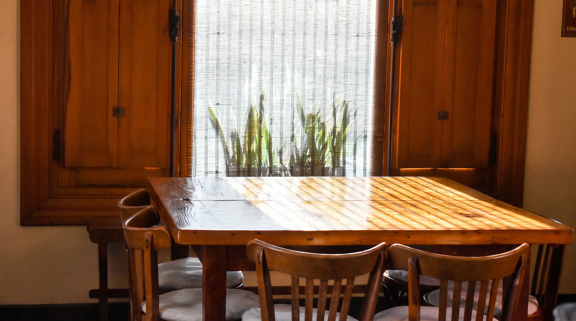 Comedor con mesa larga de madera junto a la ventana