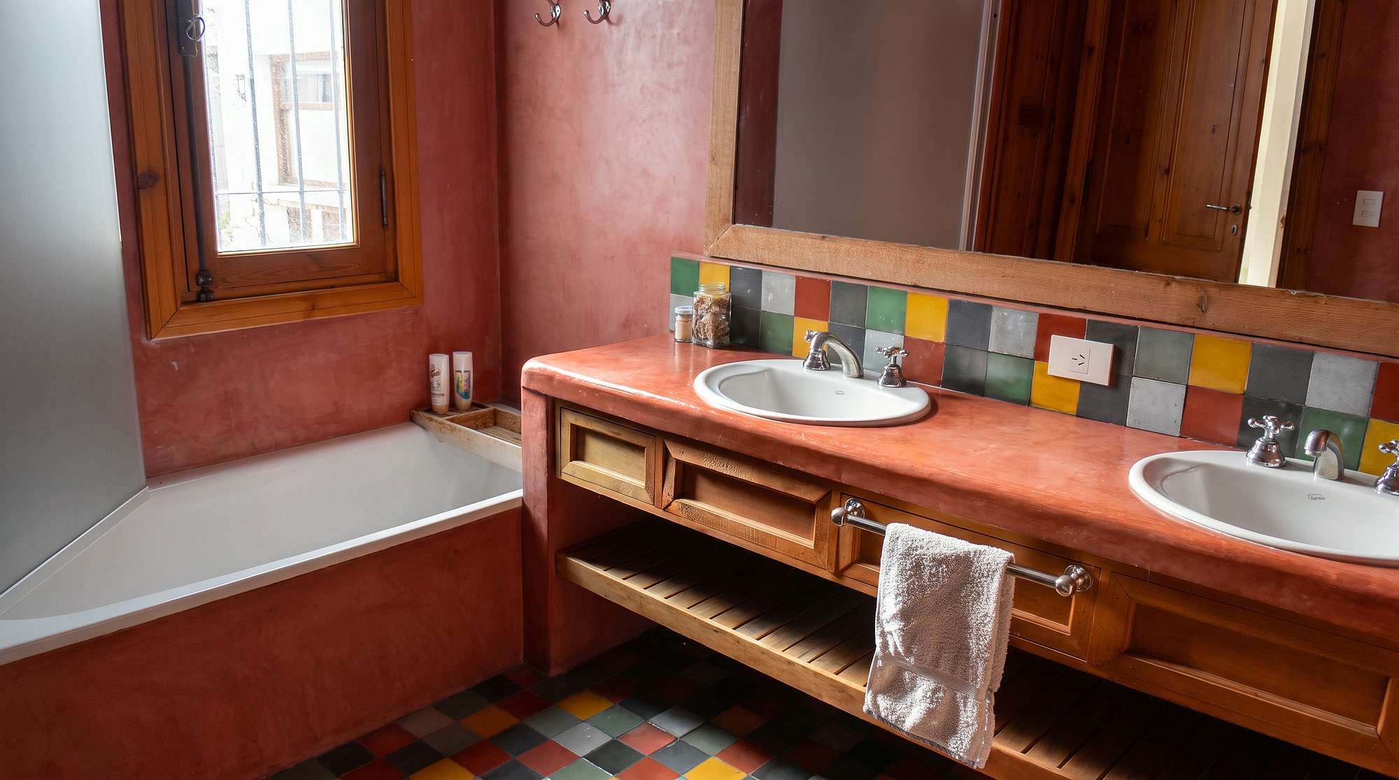 Baño con bañera, doble bacha y azulejos de colores