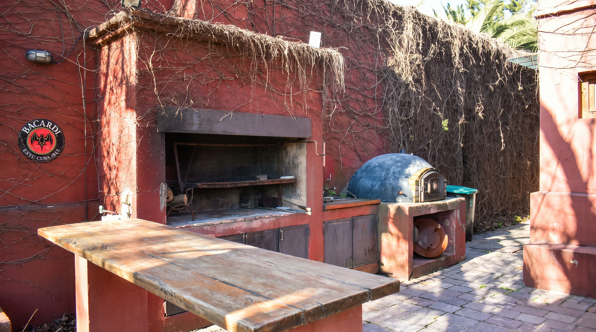 Parrilla y horno de barro bajo una enredadera